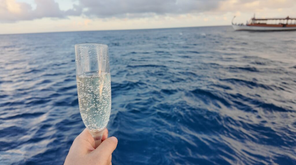 海を背景に掲げたノンアルコールシャンパンのグラス